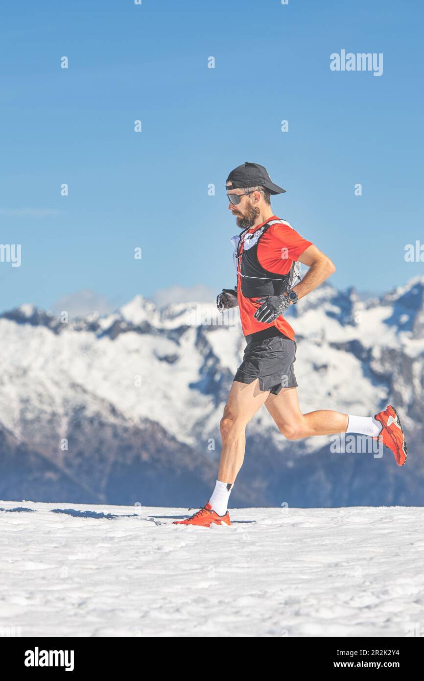 Trail-Running-Athleten laufen im Schnee in großer Höhe Stockfoto