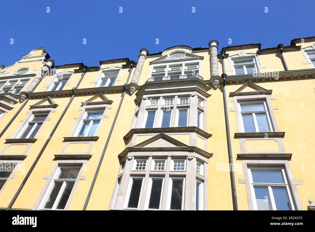 Wunderschöne gelb verzierte Fassade mit Erkerfenster in einem 1900 erbauten Wohngebäude. Stockfoto