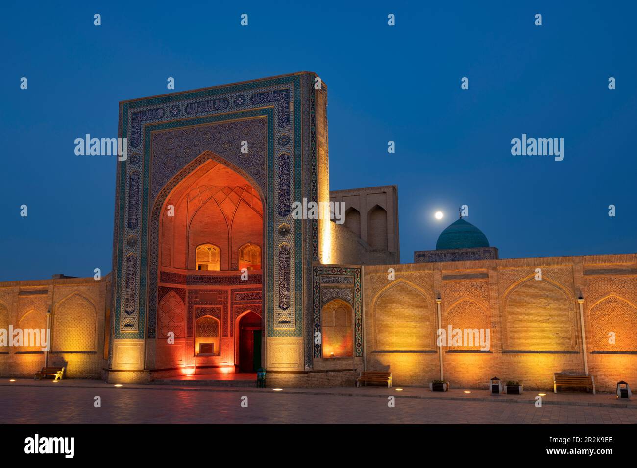 BUKHARA, USBEKISTAN - 11. SEPTEMBER 2022: Portal der antiken Kalyan-Moschee (POI-Kalyan) in farbenfroher Nachtbeleuchtung Stockfoto