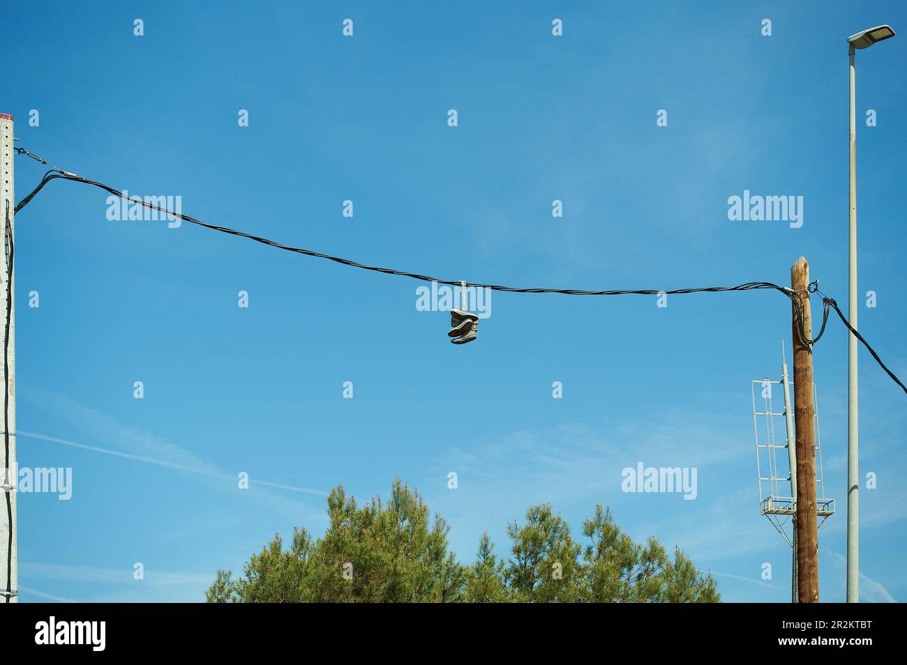 Mehrere Paar Sportschuhe hängen an elektrischen Kabeln. Stockfoto