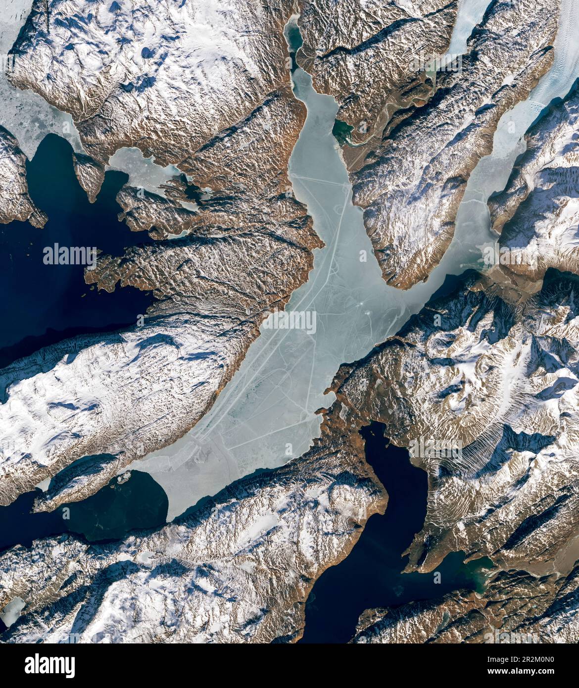 Schneemobilstrecken über den Tunulliarfik Fjord aus der Vogelperspektive, die die Städte mit geraden Linien verbinden, die Narsarsuaq und Qassiarsuk, Grönland, verbinden Stockfoto
