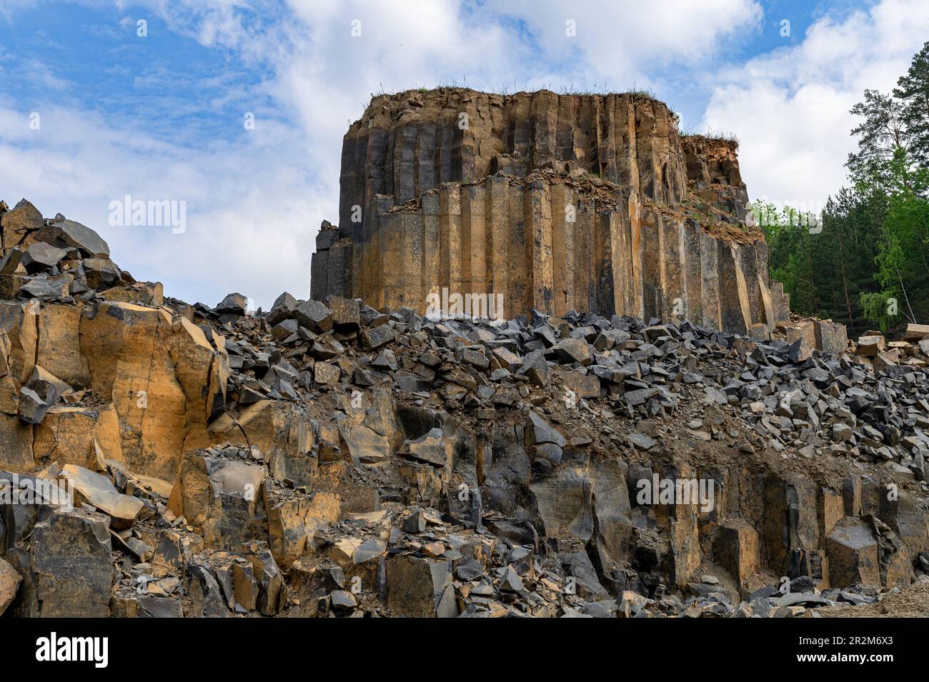 Geologische Basaltfelsformation. Basaltsteinbruch. Säulenbasaltbruch im Sommer. Vulkansteine. Stockfoto