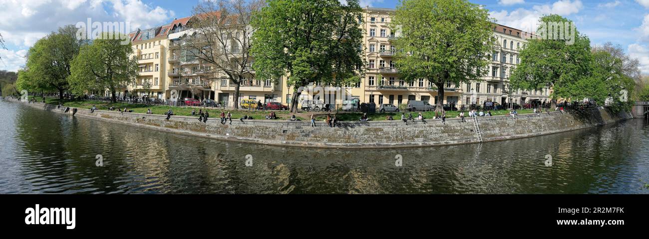 Junge Leute sitzen in Gruppen am Landwehrkanal in Kreuzberg, Berlin , Frühling, Panorama, Urbanhafen Stockfoto