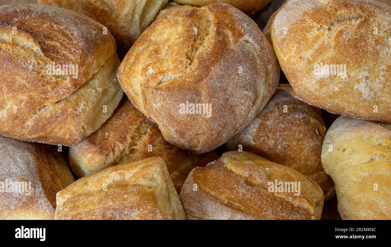Nahaufnahme des Haufens von frischem gebackenem Brot auf Holzhintergrund Stockfoto