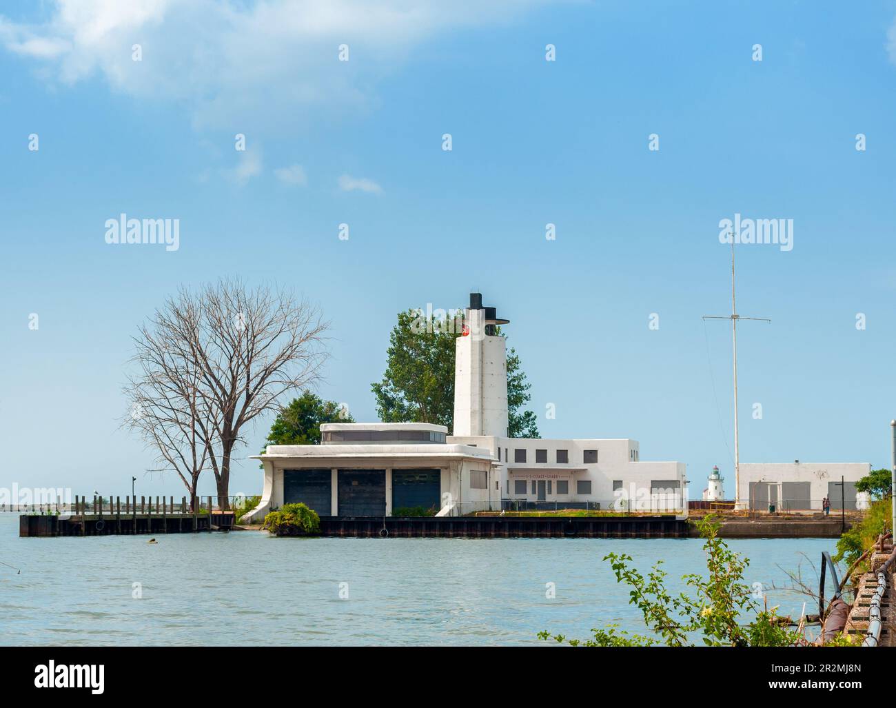 Die alte verlassene Küstenwache am Eriesee in Cleveland, Ohio, mit Leuchtturm in der Ferne Stockfoto