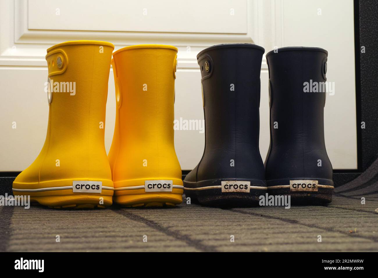 Tambov, Russische Föderation - 08. August 2019 zwei Paar Crocs Gummistiefel stehen in einem Flur neben einer weißen Tür. Stockfoto
