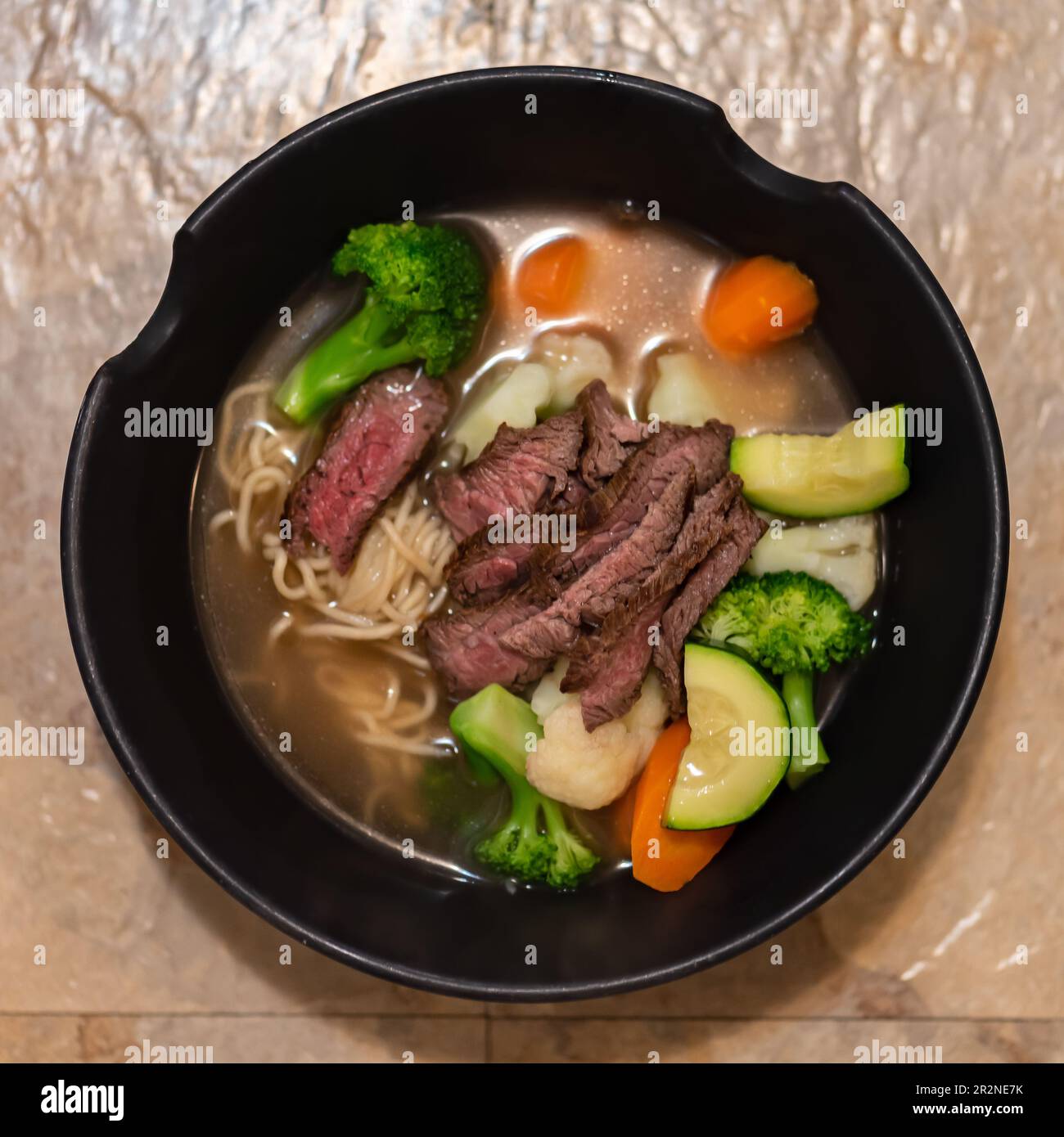 Gegrilltes Rindersteak und Sommergemüse in asiatischem Ramen-Nudelsuppe-Schüssel. Stockfoto