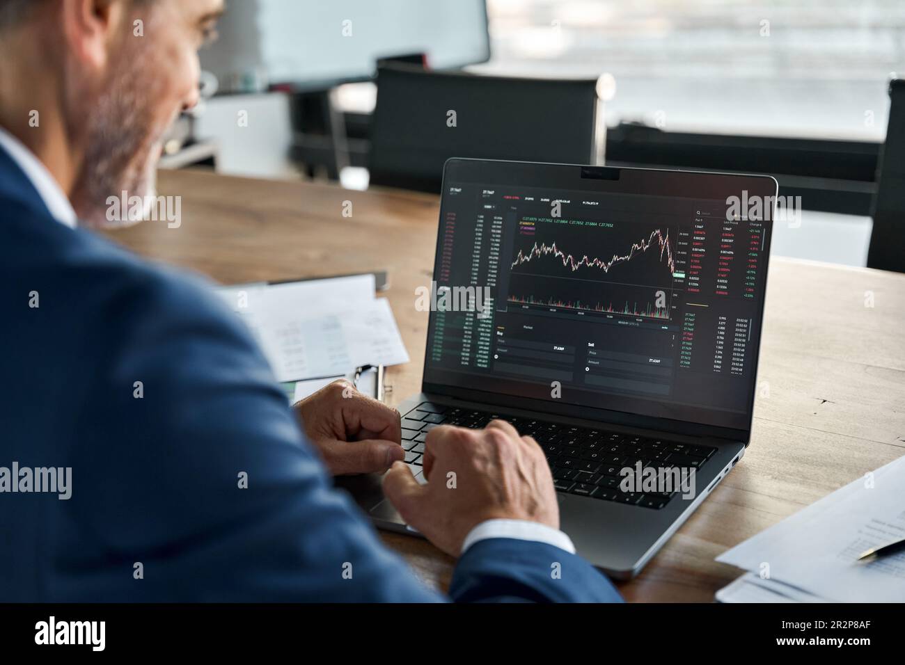 Börseninvestor analysiert Kryptomarkt auf Computerbildschirmen. Über die Schulter Stockfoto