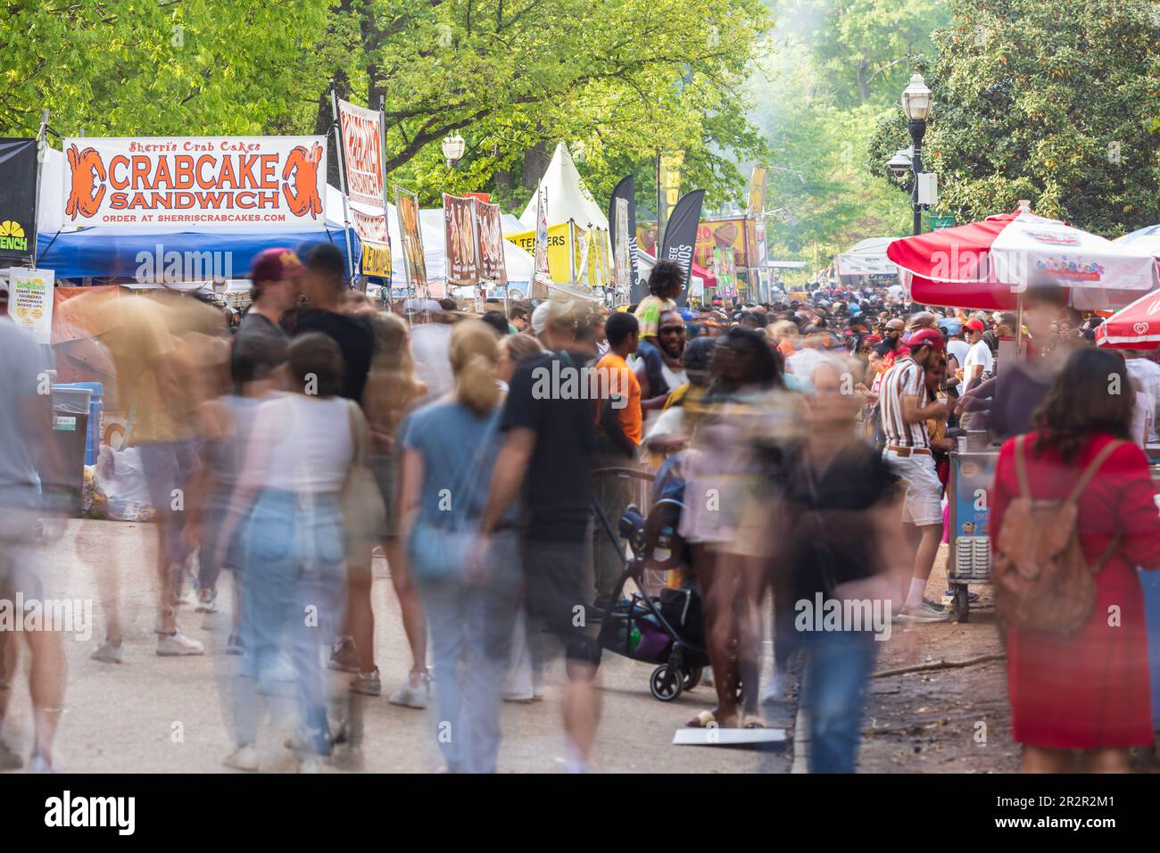 Atlanta, GA/USA - 15. April 2023: Bewegungsunschärfe von Menschen beim Atlanta Dogwood Festival am 15. April 2023, während sie sich um die Verkäuferzelte bewegen. Stockfoto