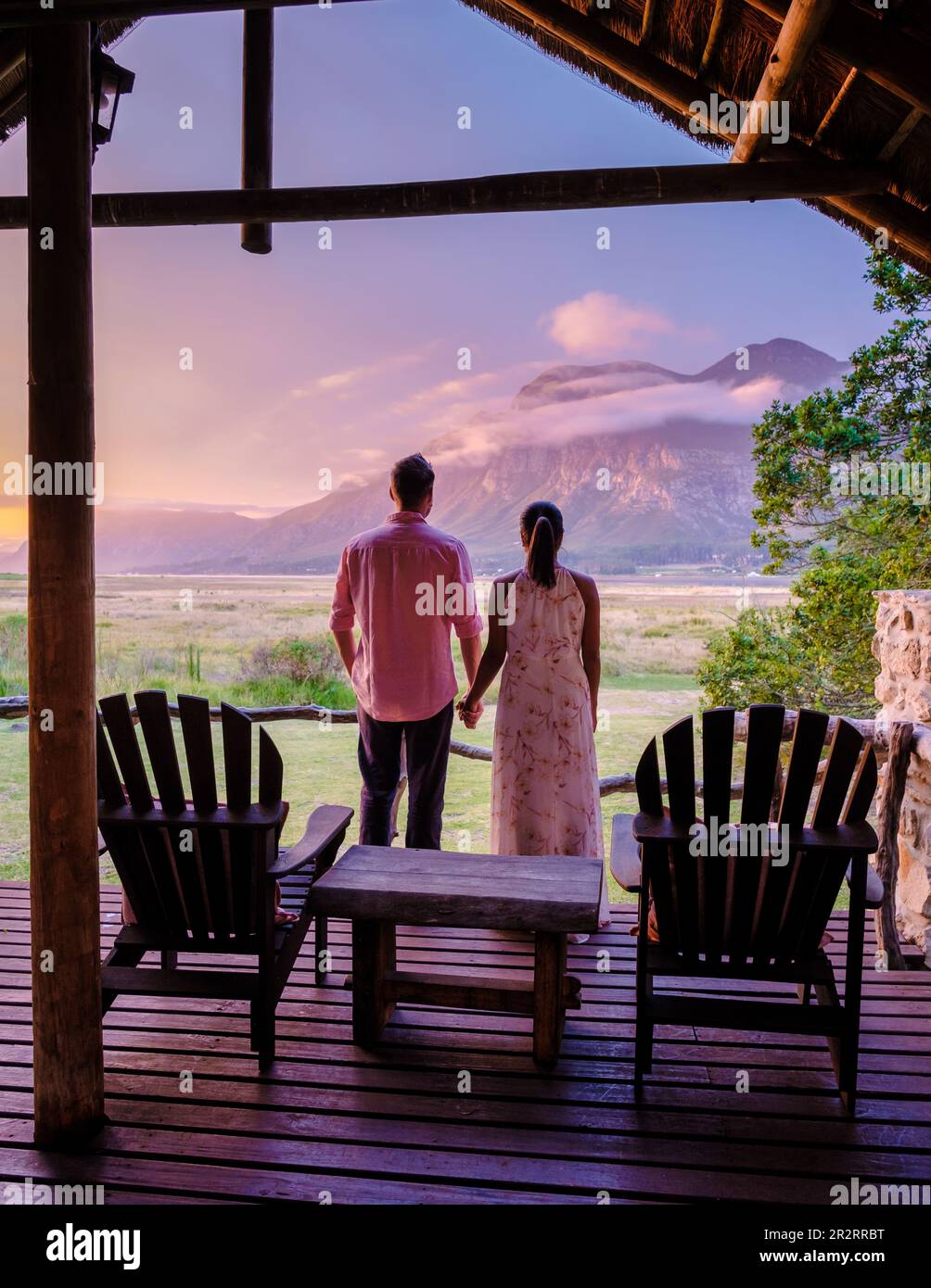 Berge und Grasland in der Nähe von Hermanus an der Garden Route Westkap Südafrikanische Walküste. Ein Paar Mann und eine Frau mittleren Alters vor ihrer Lodge während eines Urlaubs in Südafrika im Susnet Stockfoto