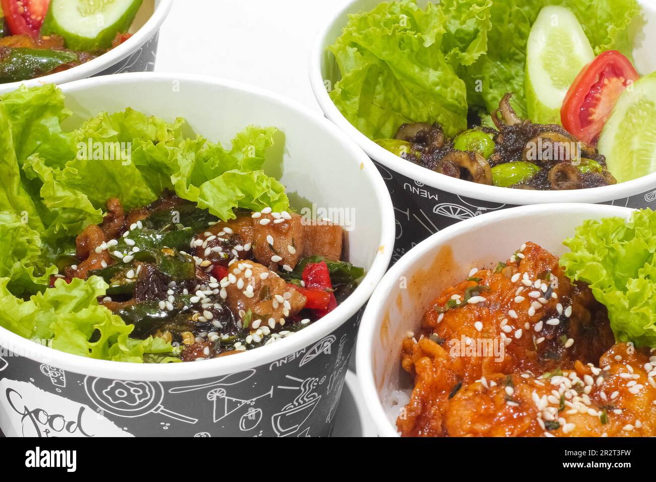 Gebratenes Hähnchen in scharfer Sauce mit Sesam und Chicken Katsu mit Gemüse isoliert auf weißem Hintergrund. Fast-Food-Konzept Stockfoto