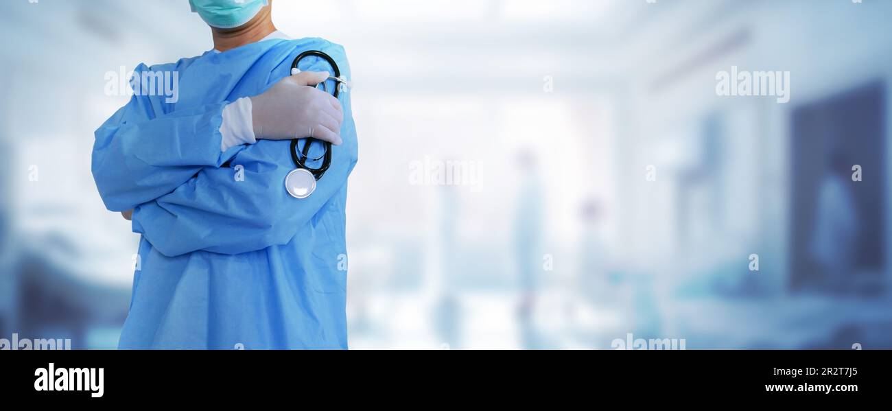 Ein Arzt, Chirurg, hält ein Stethoskop über den Hintergrund von Patienten und Krankenhauspersonal, das medizinische Konzepte im Gesundheitswesen veranschaulicht. Stockfoto