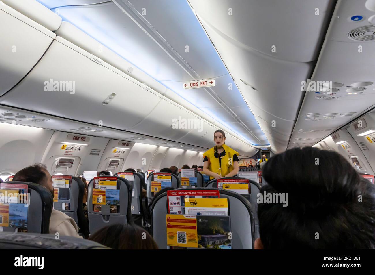 Eine weibliche Flugbegleiterin, die Passagieren eine Schwimmweste in einer Boeing 737 vorführt, die von Pegasus Airlines betrieben wird Stockfoto