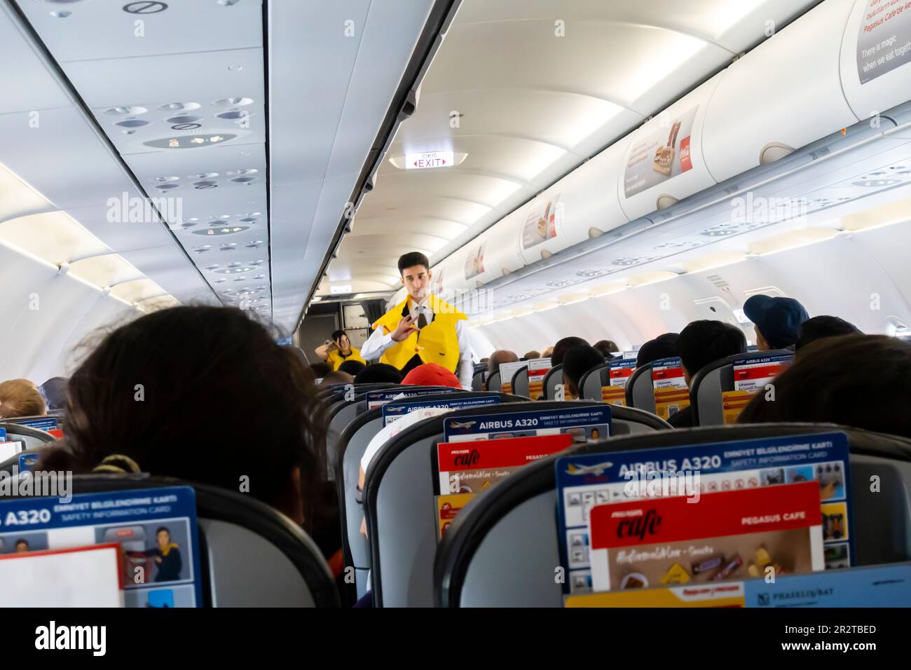 Ein männlicher Flugbegleiter, der Passagieren eine Schwimmweste in einer Boeing 737 vorführt, die von Pegasus Airlines betrieben wird Stockfoto