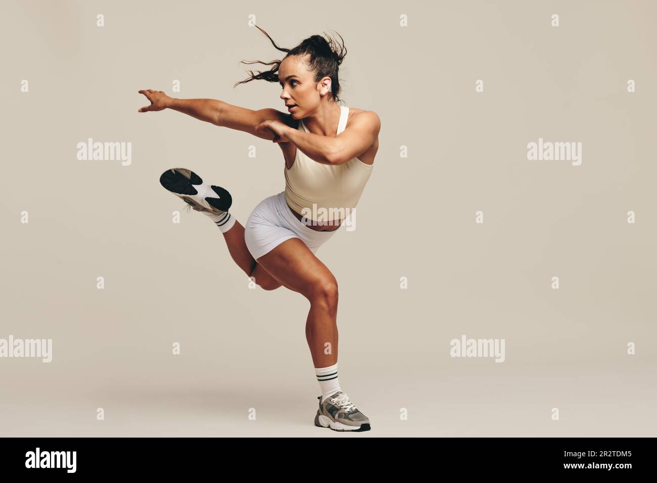 Fit Frau, die ein Krafttraining im Studio hat. Sportliche junge Frau mit intensiven Trainingseinheiten, die ihr Engagement für eine gesunde zeigt Stockfoto