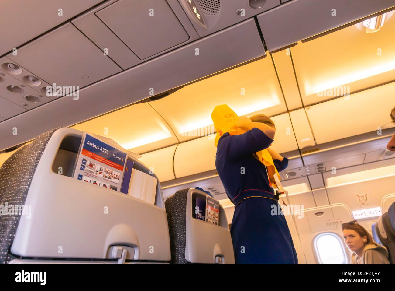 Ein Flugbegleiter, der Passagieren in einem Airbus A320-Flugzeug von Fly Arna eine Schwimmweste vorführt Stockfoto