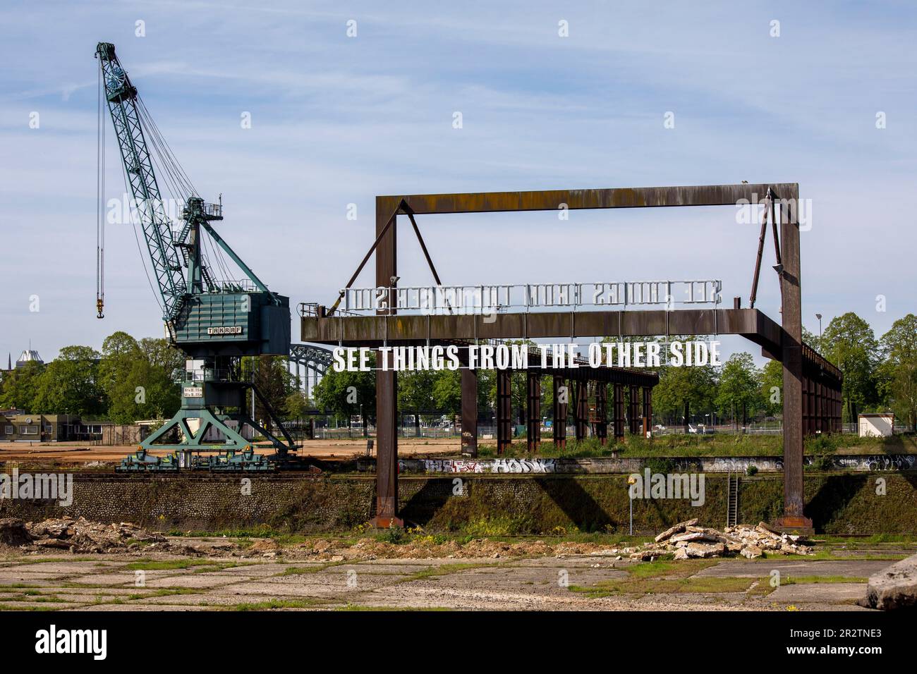 Crane und die Kunstinstallation sehen Dinge von der anderen Seite von Tim Etchells an einer alten Ladebrücke im Rheinhafen Deutz, Köln. Kr Stockfoto