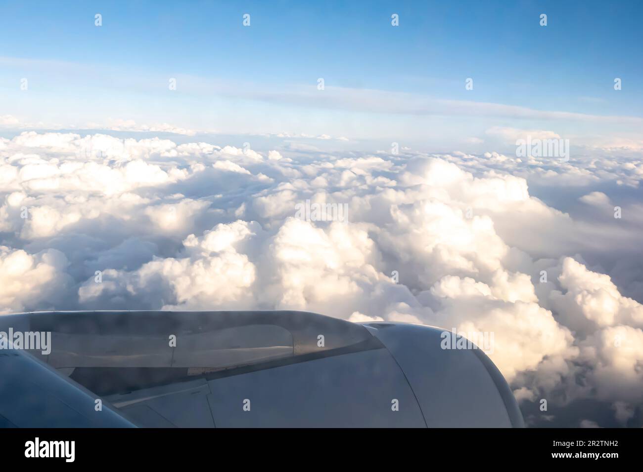 Wolken durch den Düsentriebwerk - Luftaufnahme von einem Fenstersitz im Flugzeug Stockfoto