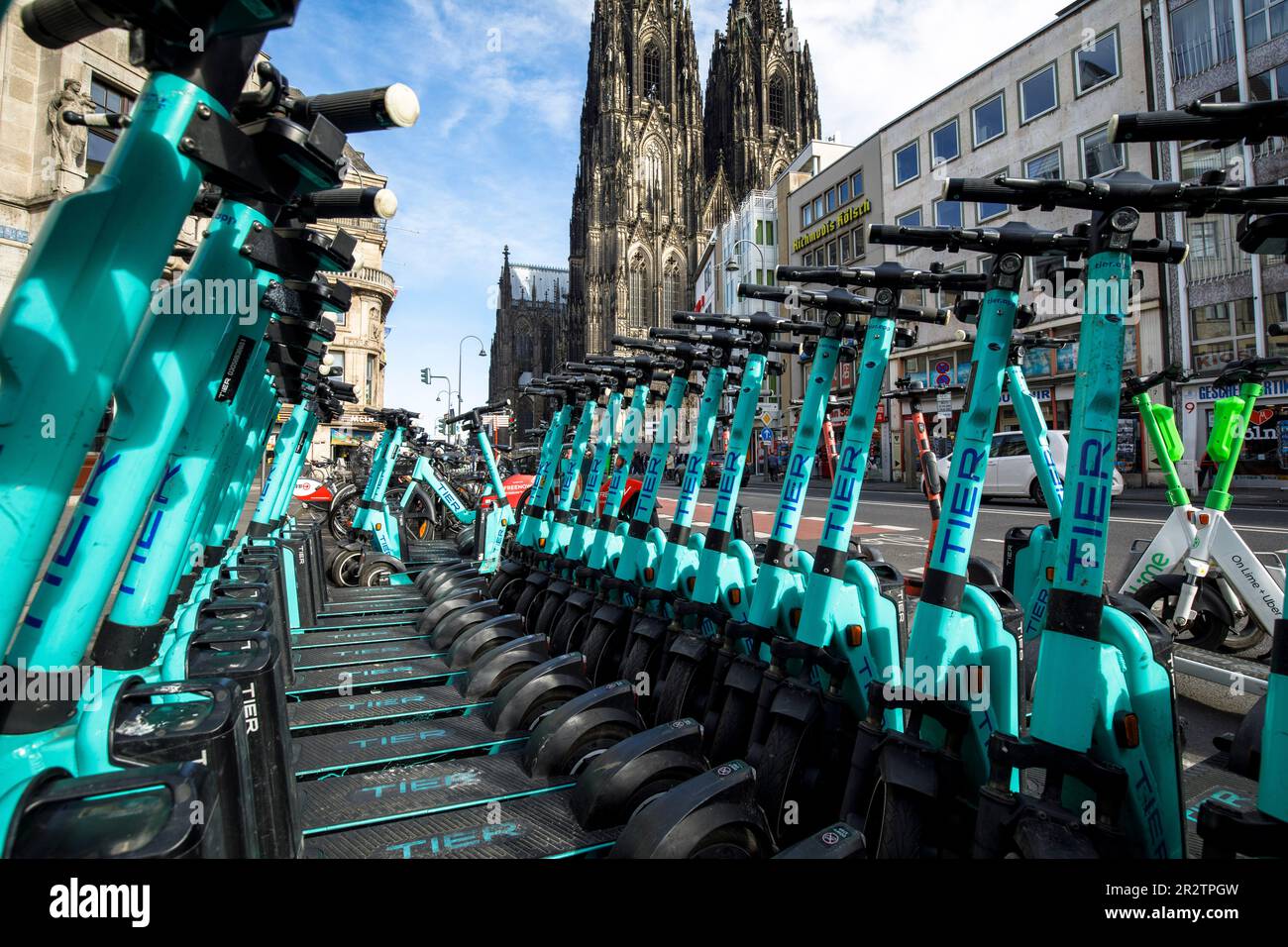 Die gemieteten Elektroroller auf der Komoedien-Straße in der Nähe des Doms, Köln, befinden sich auf dem Parkplatz. Tier Elektroscooter zum mieten stehen an der Komo Stockfoto