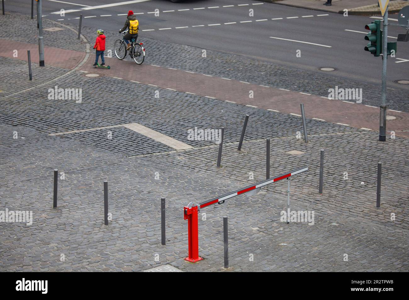 Rot-weiße Barriere am Harry-Blum-Platz im Rheinau Hafen, Kind in roter Jacke und Radfahrer, Köln, Deutschland. Rot-weisse Schranke am Harry-Blum-Platz Stockfoto