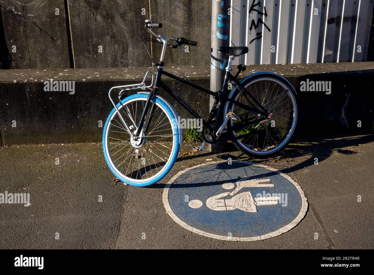 Fahrrad parkt auf einem Fußweg im Stadtteil Deutz, Köln. Auf einem Fussweg abgestelltes Fahrrad im Stadtteil Deutz, Köln, Deutschland Stockfoto