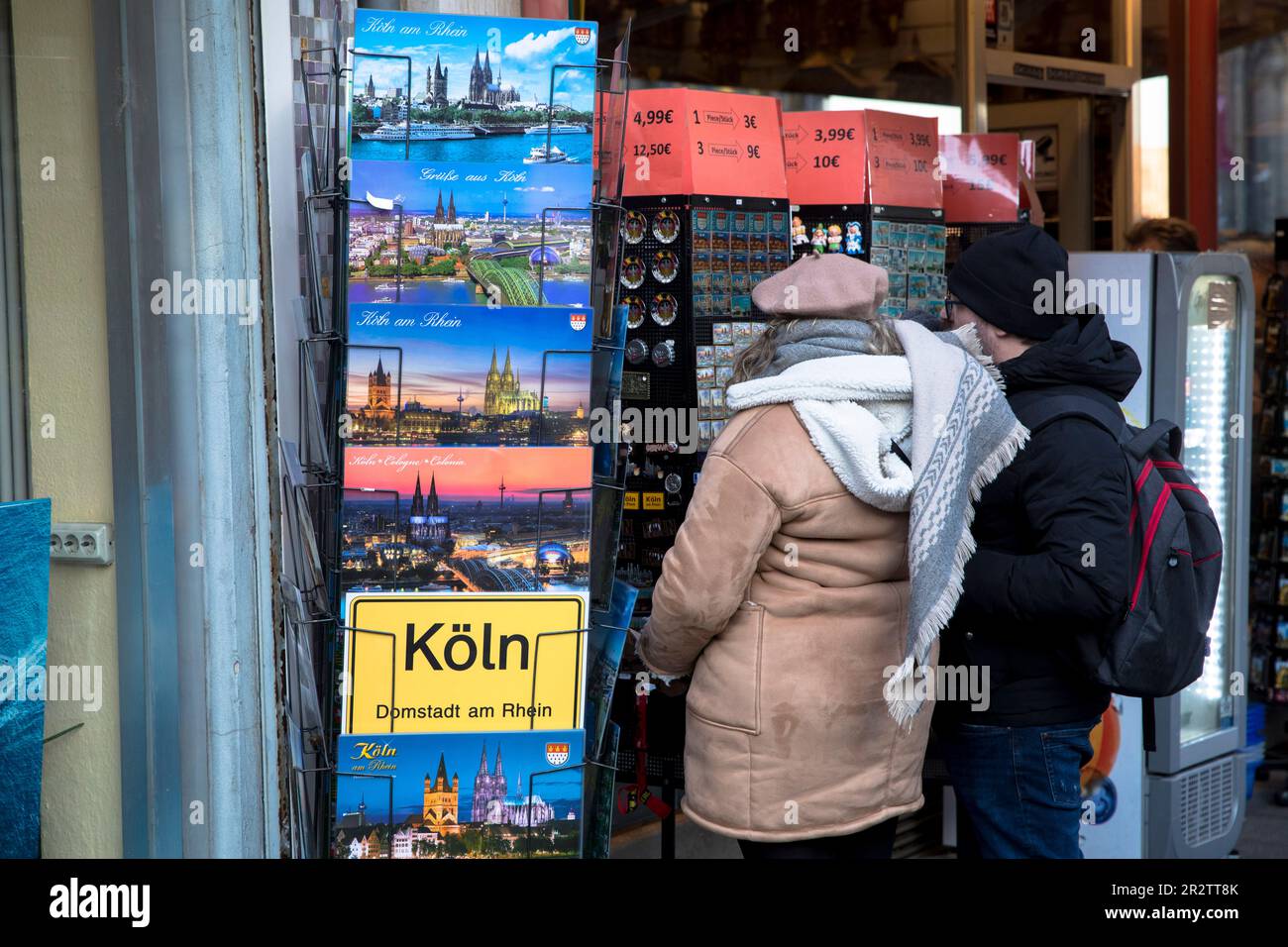 Regale mit Plakaten und Aufklebern vor einem Souvenirladen in der Nähe des Doms, Köln. Staender mit Poster und Aufkleber vor einem Souvenirsh Stockfoto