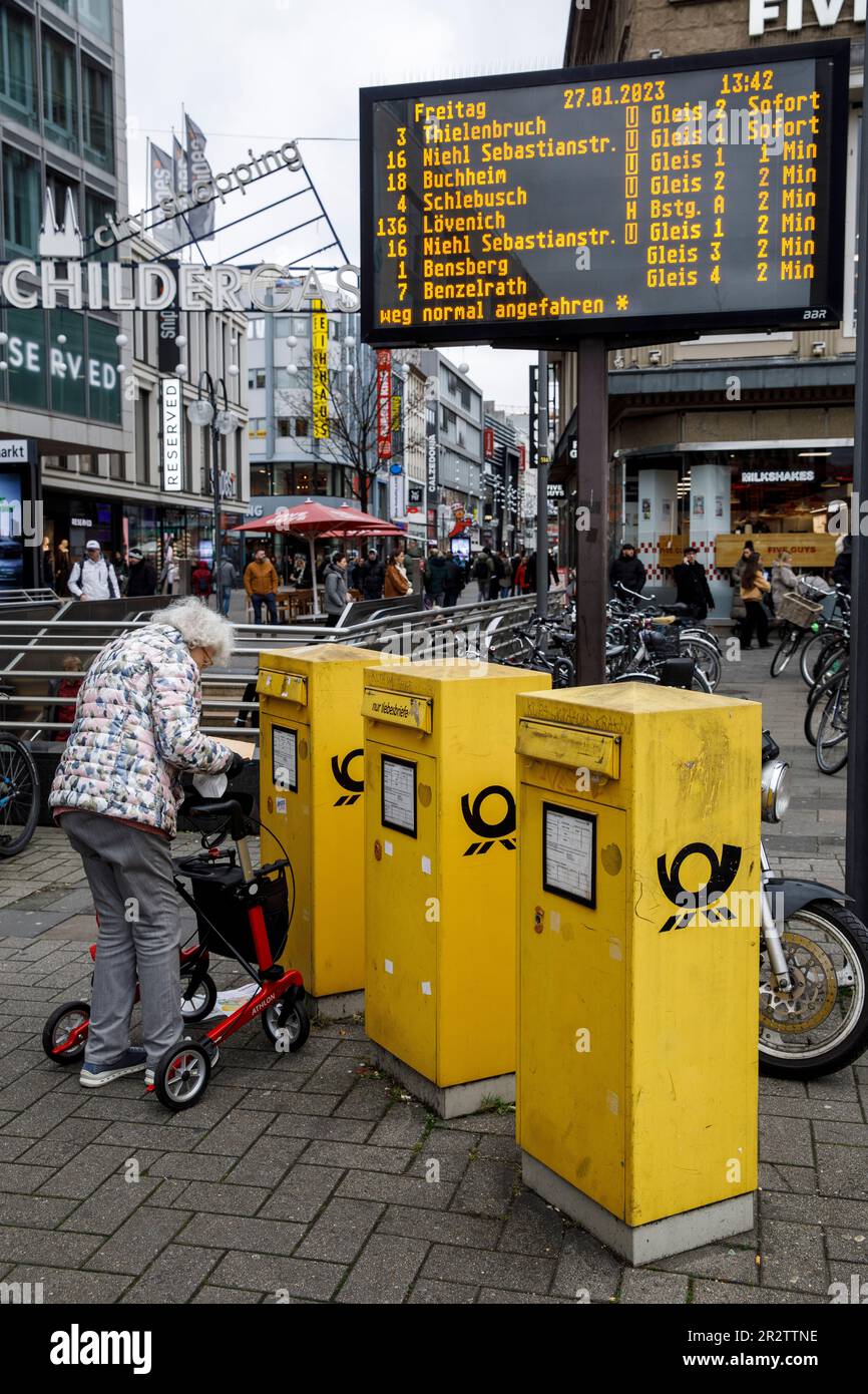 Eine ältere Frau mit Rollator wirft Briefe in einen Briefkasten in Neumarkt, Schildergasse, Köln. Eine Aeltere Frau mit Rollator wirft Brief Stockfoto