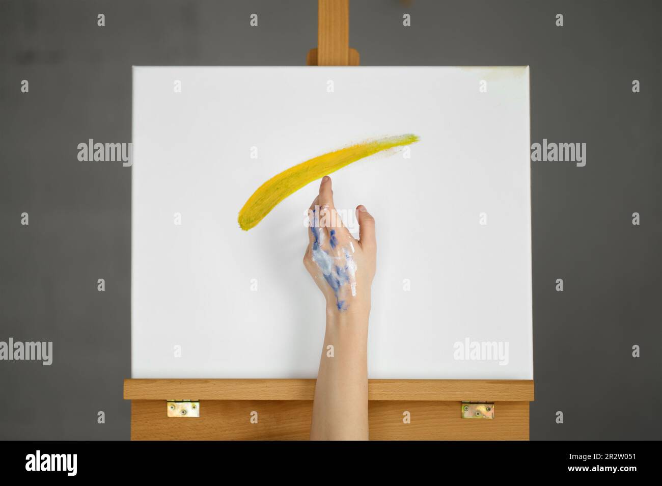 Schmutzige Künstlerhand über Leinwand, die magische Bewegungen macht Stockfoto