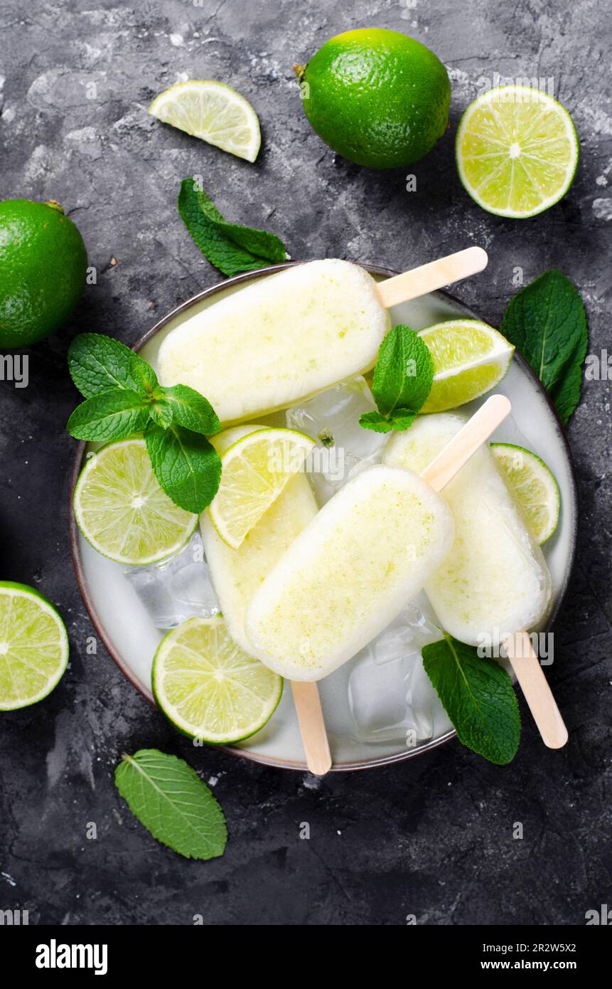 Erfrischendes Limetteneis, brasilianisches Limonadeneis Lolly mit frischer Limette und Mint auf dunklem Hintergrund, gesundes Dessert Stockfoto