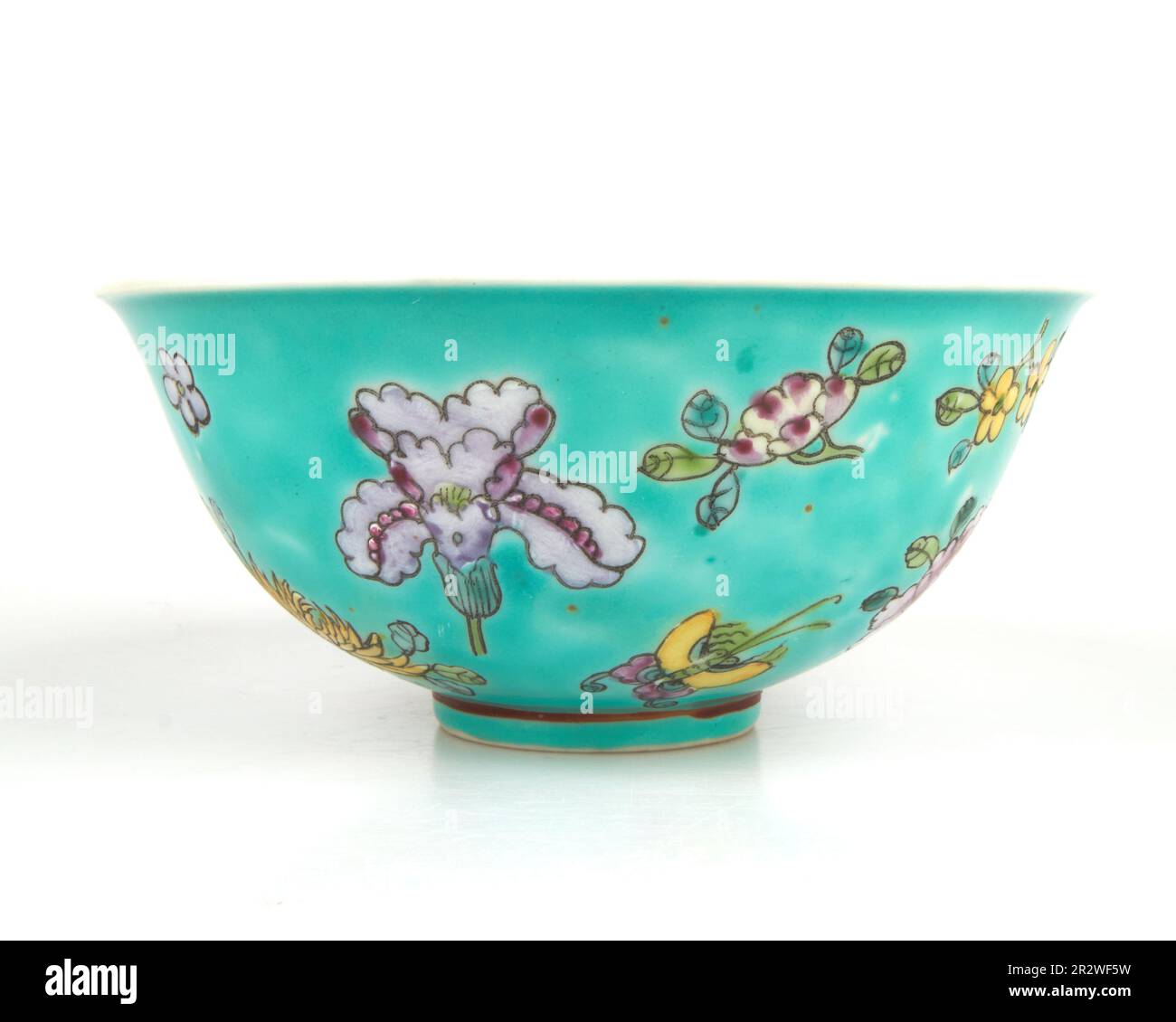 Antike, handbemalte chinesische Schmetterlinge und Blumen in türkisfarbener Schüssel Stockfoto
