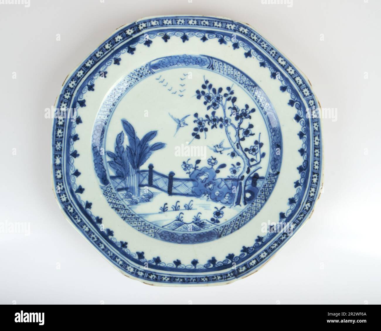 Antike 18-19.c Chinesische blaue und weiße Vögel in umzäunten achteckigen Porzellanplatten im Garten Stockfoto