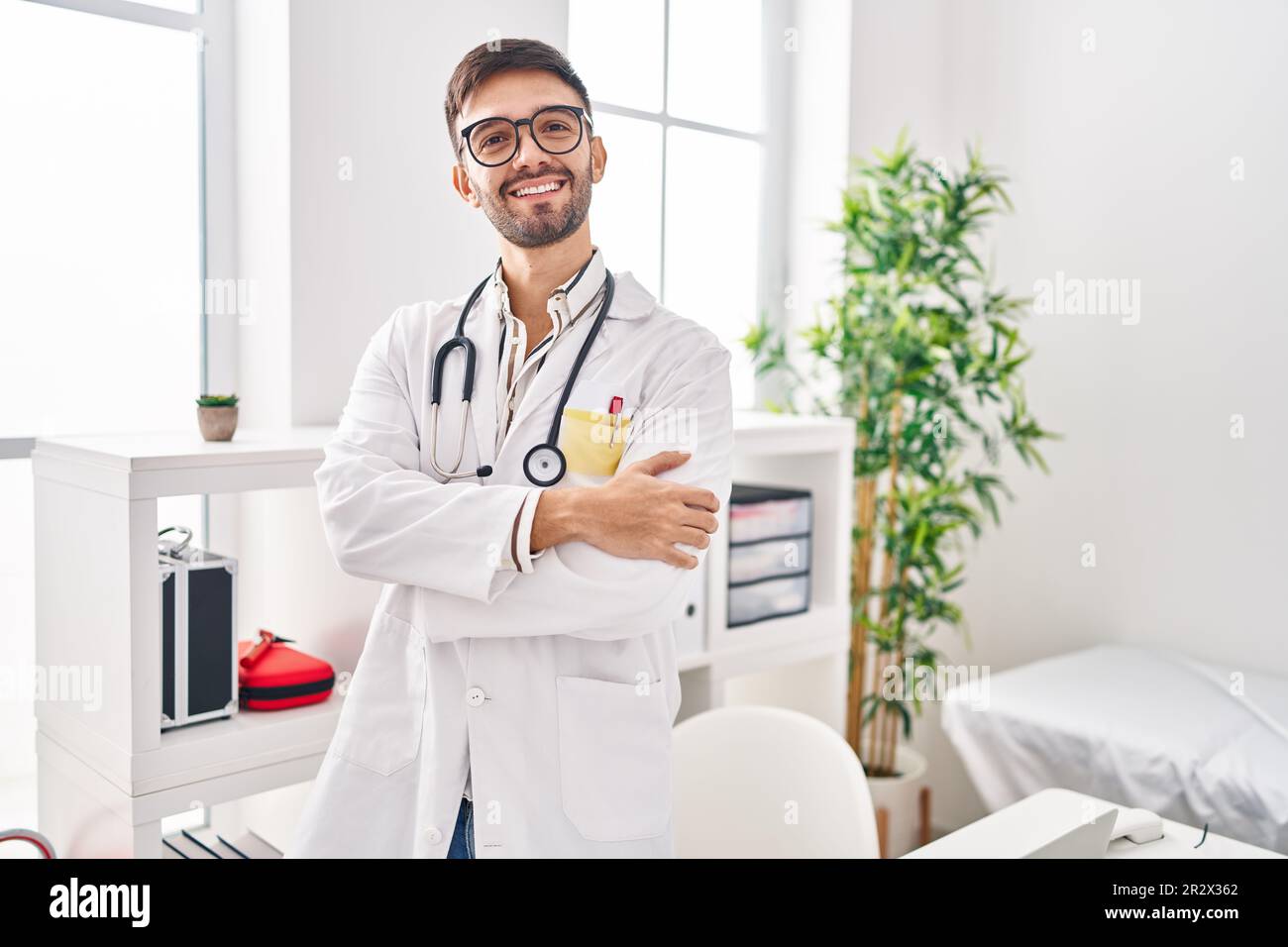 Lateinamerikanischer Mann in Arztuniform und Stethoskop, fröhliches  Gesicht, mit gekreuzten Armen und Blick in die Kamera. Positive Person  Stockfotografie - Alamy