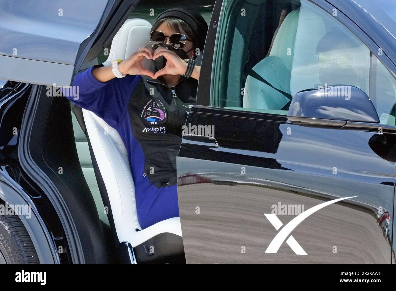 Saudi Arabian astronaut Rayyanah Barnawi makes a heart with her hands as she heads out to prepare for this evening's launch aboard a SpaceX Falcon 9 rocket at Kennedy Space Center in Cape Canaveral, Fla., Sunday, May 21, 2023. (AP Photo/John Raoux) Stockfoto