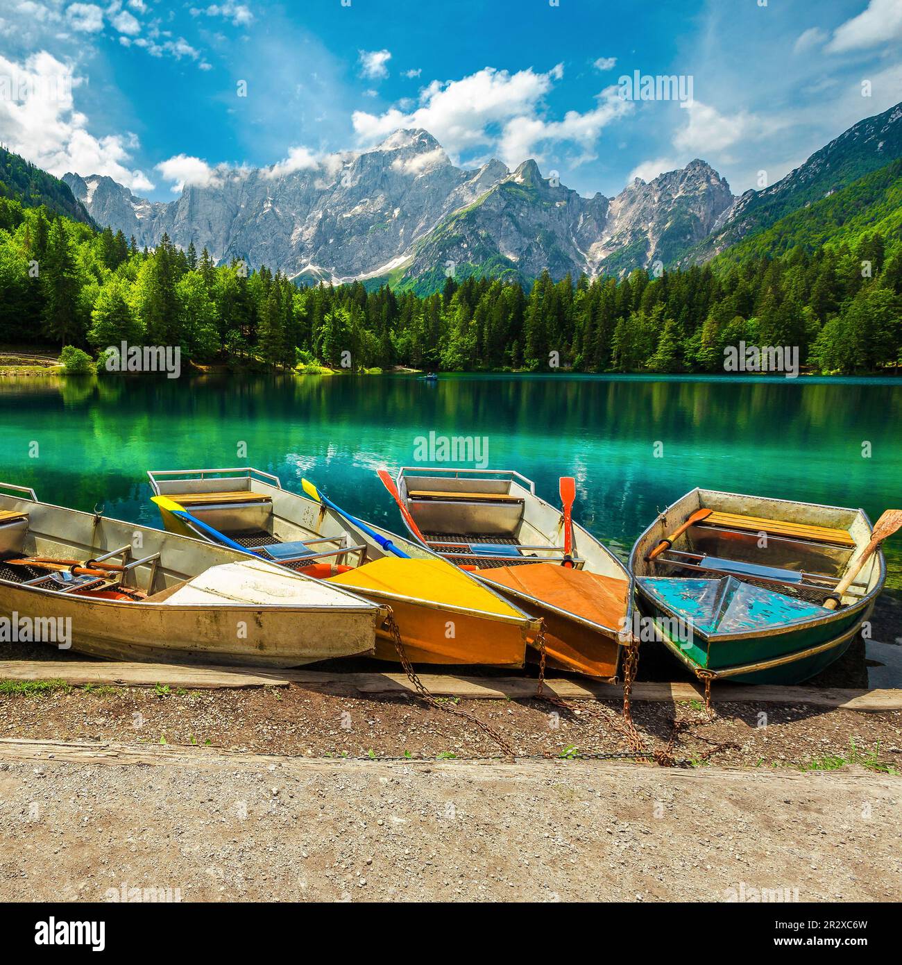 Fantastischer Ort mit bunten Ruderbooten auf dem Fusine-See und wunderschönen nebeligen Bergen im Hintergrund, Italien, Europa Stockfoto