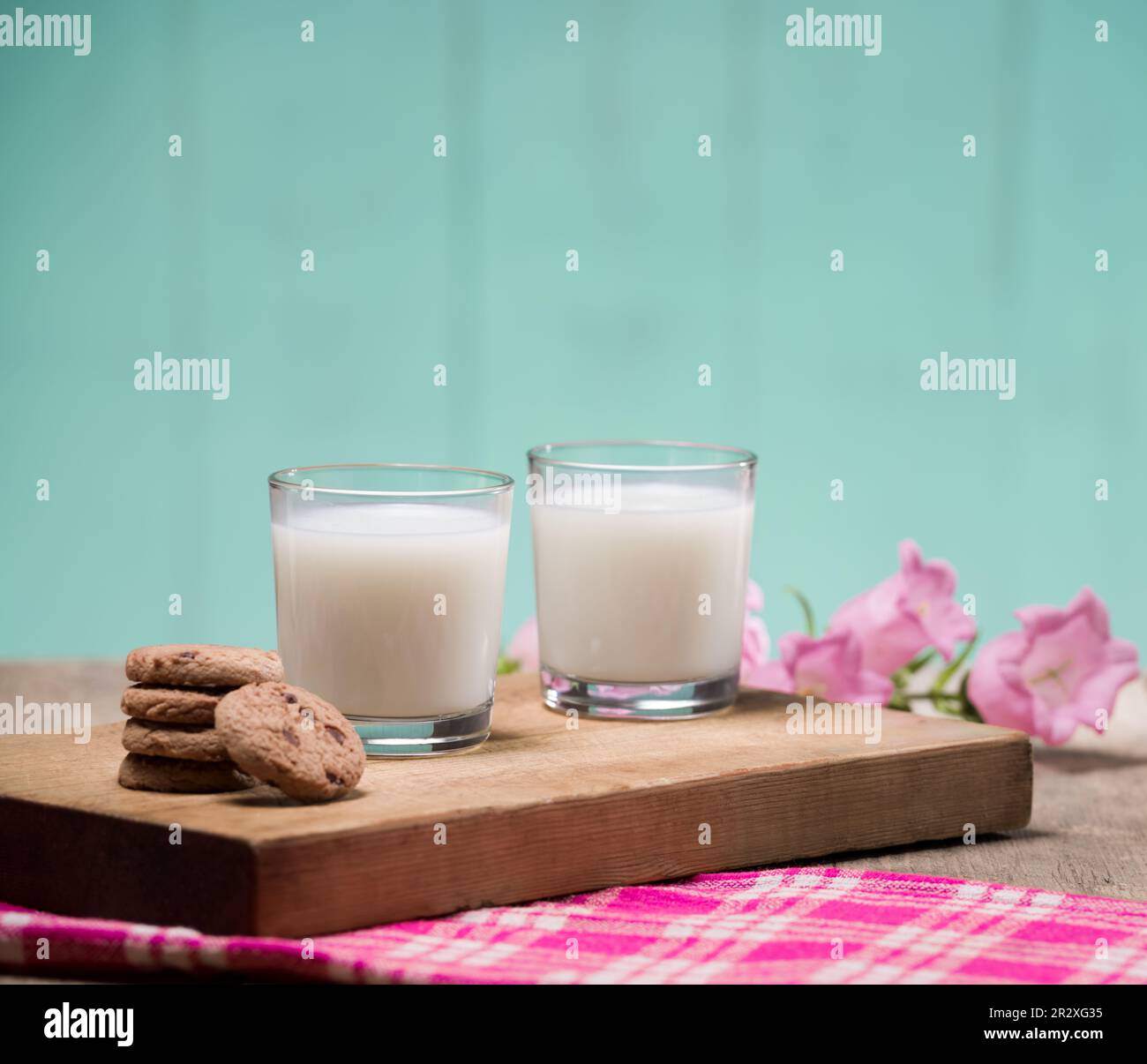 Gläser Milch und Kekse auf dem Schneidebrett. Zwei Gläser mit frischer Milch. Stockfoto