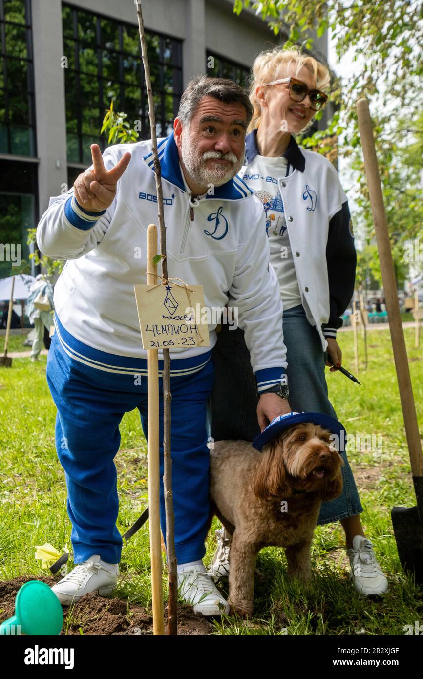 Moskau, Russland. 21. Mai 2023. Bosco di Ciliegi, Präsident Michail Kusnirowitsch, und seine Frau besuchen Ekaterina Moiseeva, die wilde Kirschbäume im Dynamo Park anlässlich des hundertjährigen Bestehens des Dynamo Moskau im Rahmen des Kirschwaldfestes in Moskau, Russland, pflanzt. Auf dem Banner steht „Dynamo“. Stockfoto