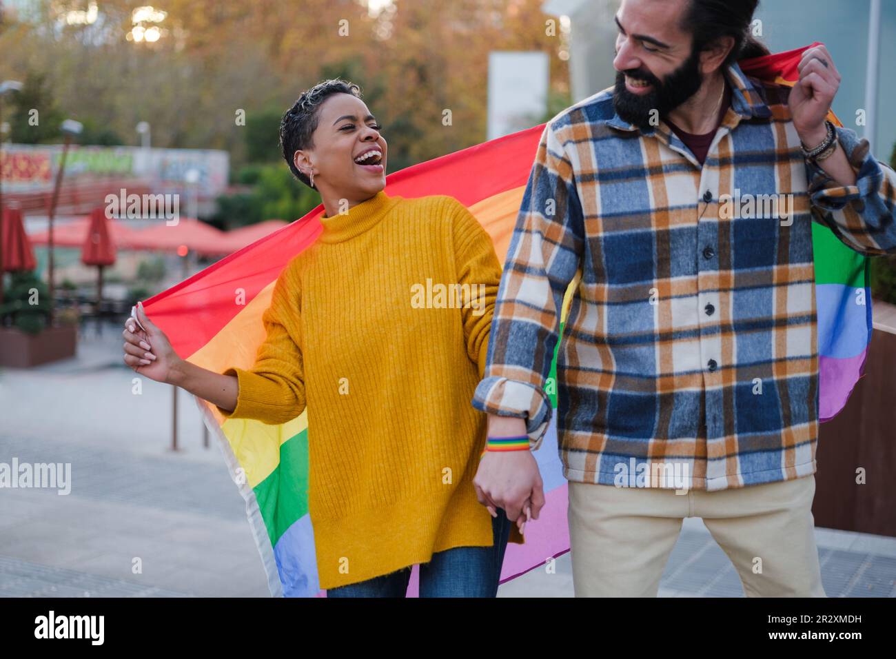 Zwei Freunde feiern den lgtbi-Tag mit der Regenbogenflagge. Konzept: Stolz, Symbole, Bürgerrechte Stockfoto