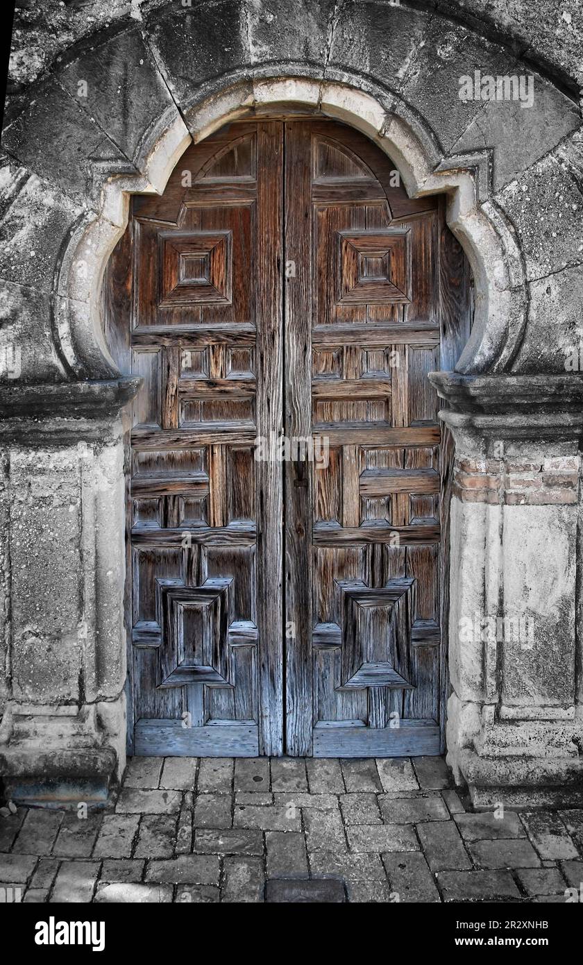 Diese altmodischen, handgefertigten Holztüren führen in eine historische Kapelle, die 1731 in der Mission Espada, südlich von San Antonio, Texas, USA, erbaut wurde. Stockfoto
