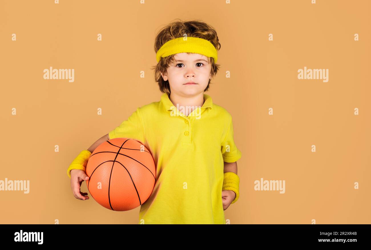 Kleiner Basketballer mit Basketballball. Sportlicher Junge in Uniform beim Basketballspielen. Profisport. Basketballtraining. Süßes Kind Stockfoto