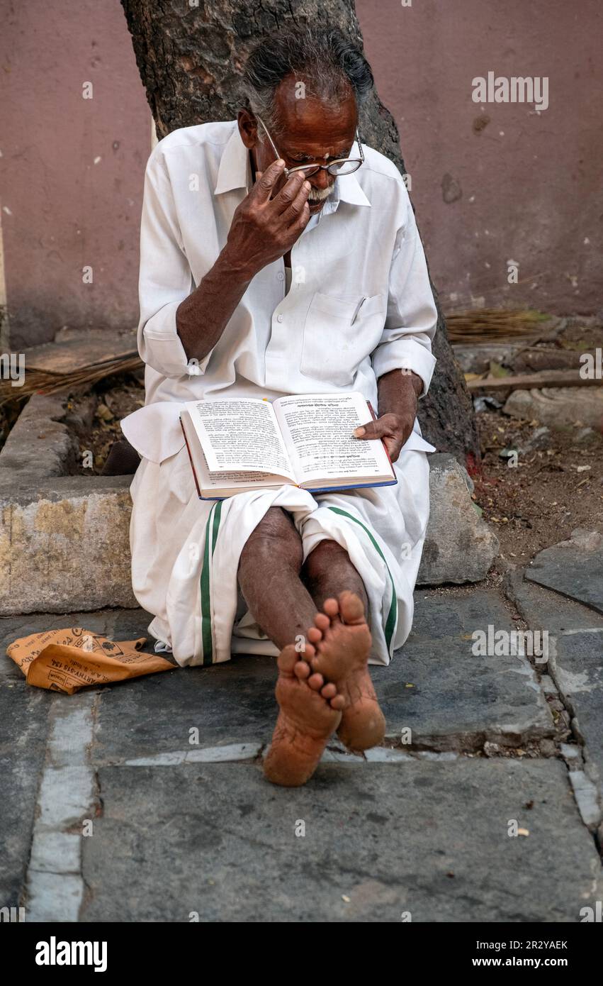 Ein älterer Indianer liest ein Hindu-Buch Stockfoto