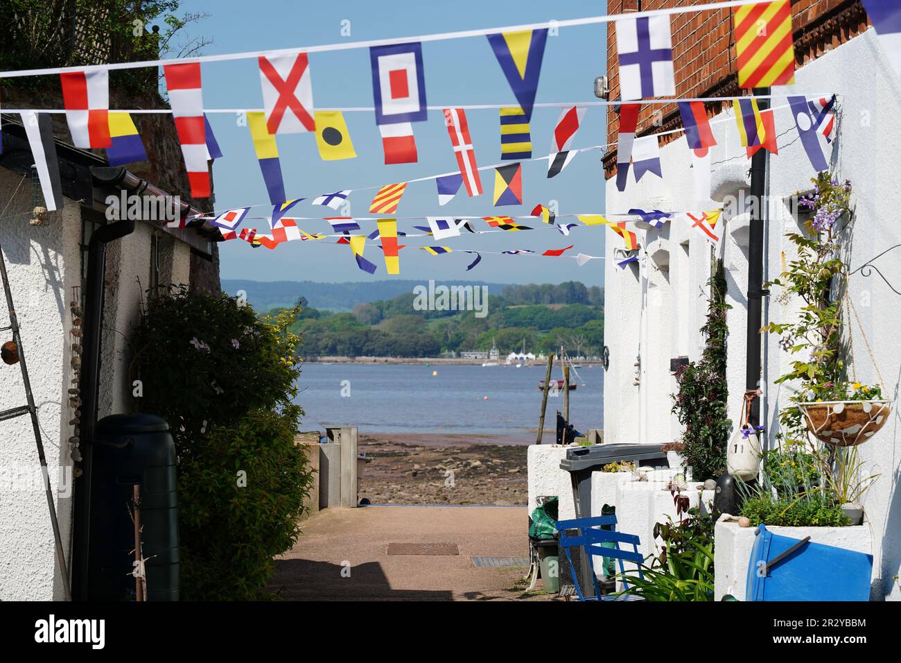 Englischer Innenhof mit internationalen Seesignalflaggen, Bolling und Meer im Hintergrund Stockfoto
