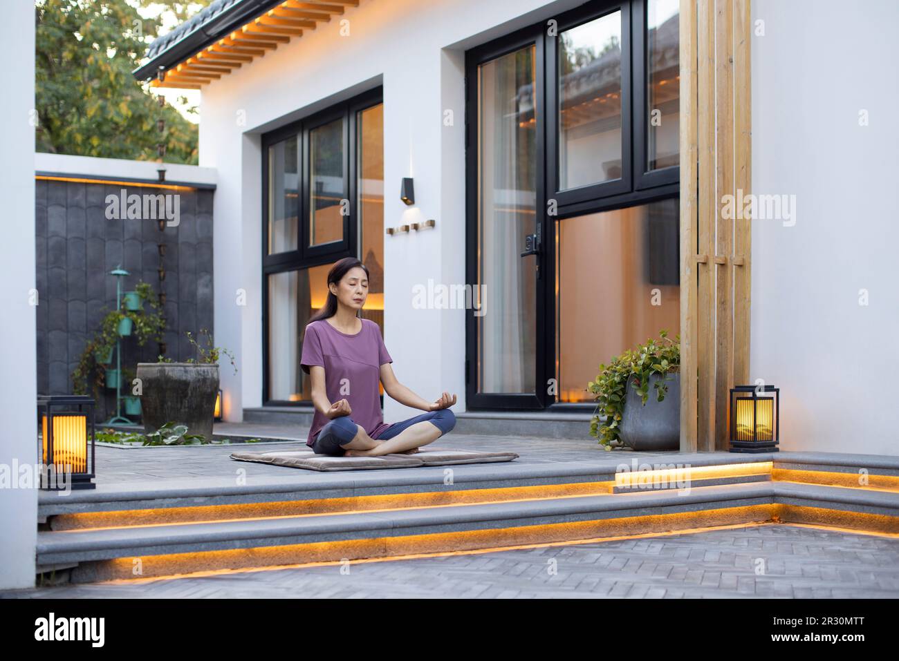 Reife Chinesin, die im Freien Yoga macht Stockfoto