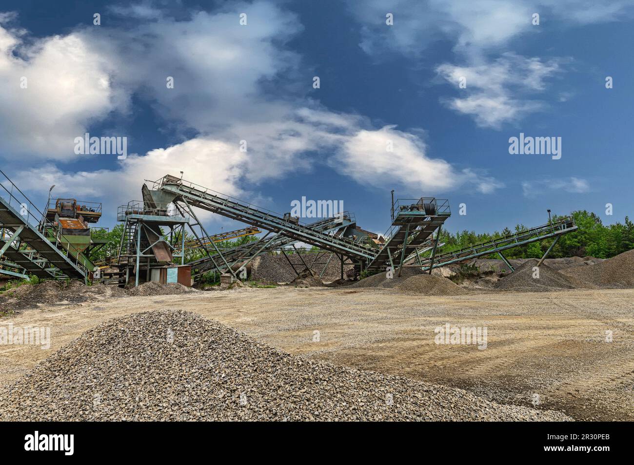 Steinbruchförderer für die Minningindustrie. Brechmaschinen, Kegelsteinbrecher, Förderer von zerdrücktem Granitkiesstein in einem Steinbruch-Minin Stockfoto