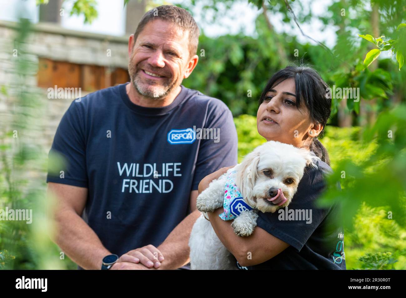 London, Großbritannien. 22. Mai 2023 Der Tiermoderator Steve Backshall (L), Daisy, ein RSPCA-Rettungshund, und ein RSPCA-Mitarbeiter im RSPCA Garden, der zeigt, wie Plastikstreu wilde Tiere am Pressetag der RHS Chelsea Flower Show auf dem Gelände des Royal Hospital Chelsea gefährdet. Die Show läuft bis zum 27. Mai 2023. Kredit: Stephen Chung / Alamy Live News Stockfoto