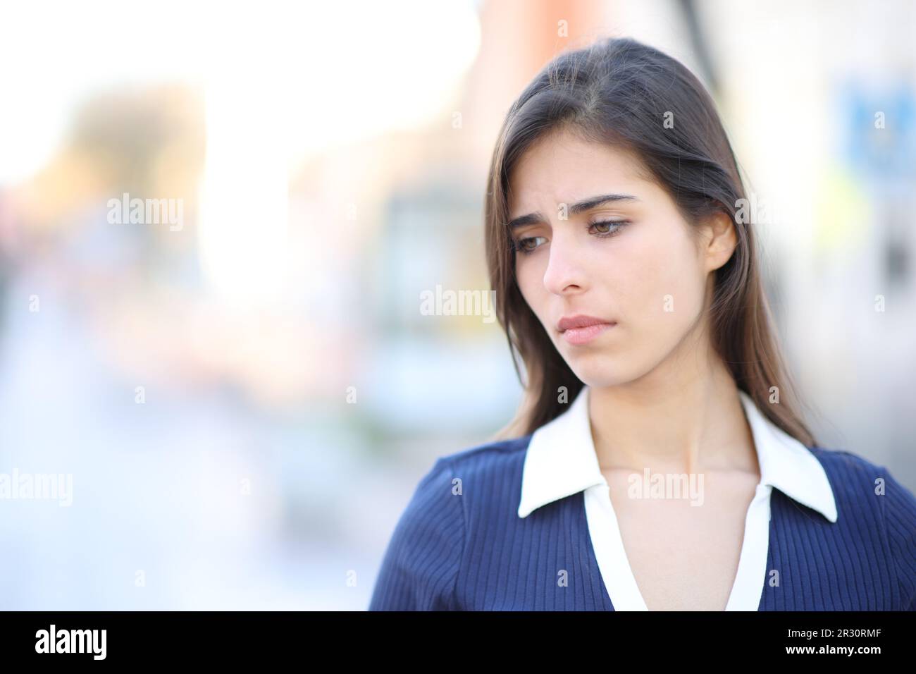 Traurige Frau, die sich beschwert, als sie auf der Straße runterschaute Stockfoto