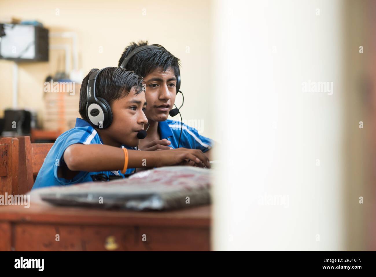 Peruanische Kinder lernen Englisch am Computer im Klassenzimmer Stockfoto