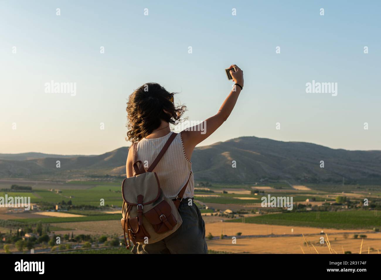 Eine junge Frau macht ein Selfie mit ihrem Smartphone auf dem Gipfel des Berges Stockfoto