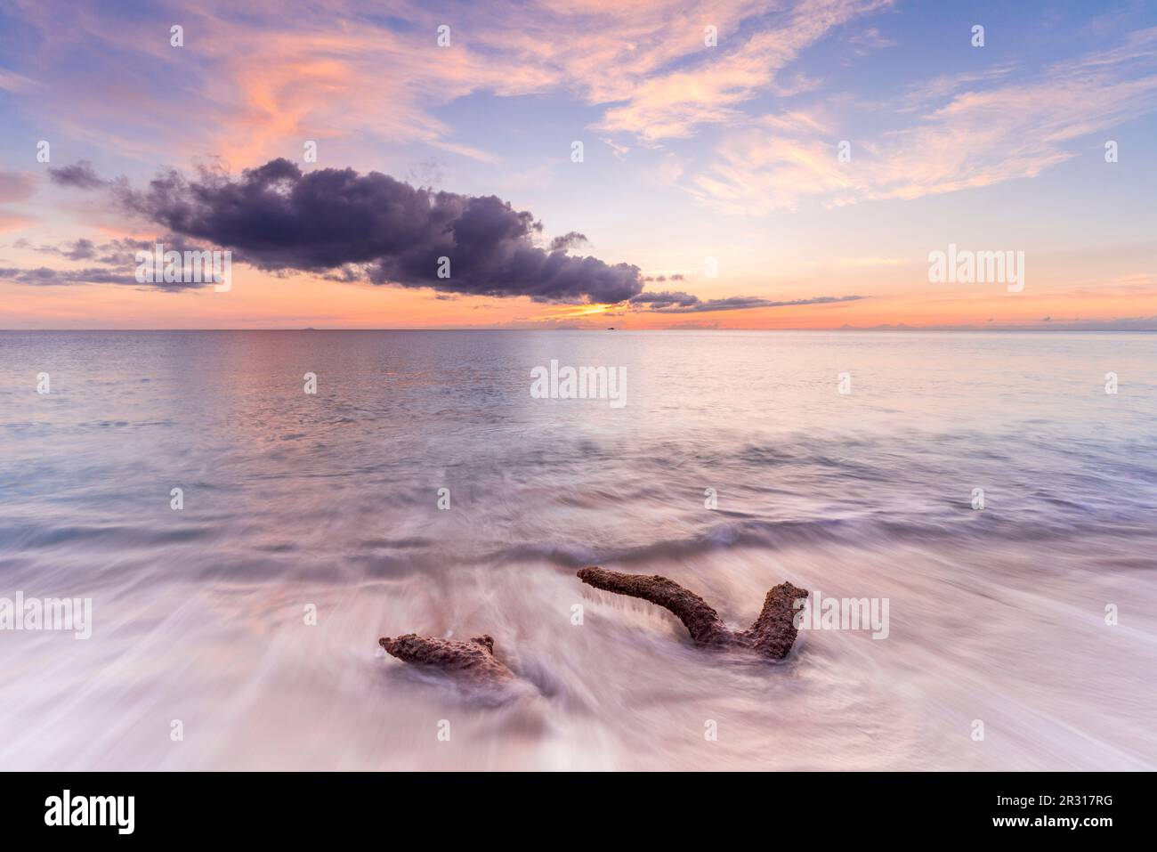 Tropischer Sonnenuntergang auf weißem Sandstrand, der vom Karibischen Meer gespült wird Stockfoto