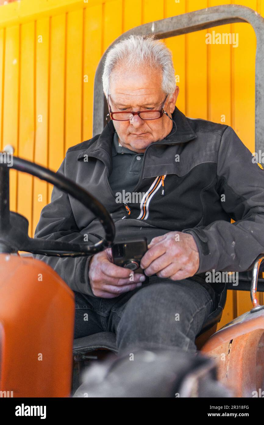 Älterer Mann aus dem modernen Land, der mit dem Smartphone arbeitet Stockfoto