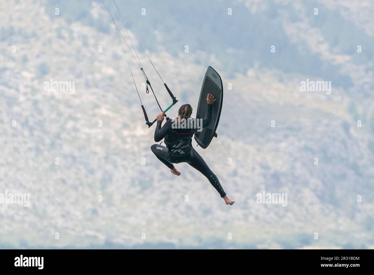 Person hob sich in die Luft, während Kite-Surfen, Porto Pollensa, Mallorca, Spanien, 19. Mai 2023 Stockfoto